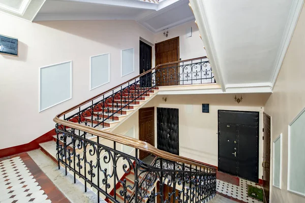 Staircase with forged railings on the railing in the old stairwell