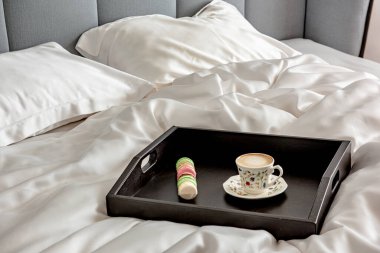 Sabahları büyük bir yatakta, çarşafın üzerinde kahve tepsisi.