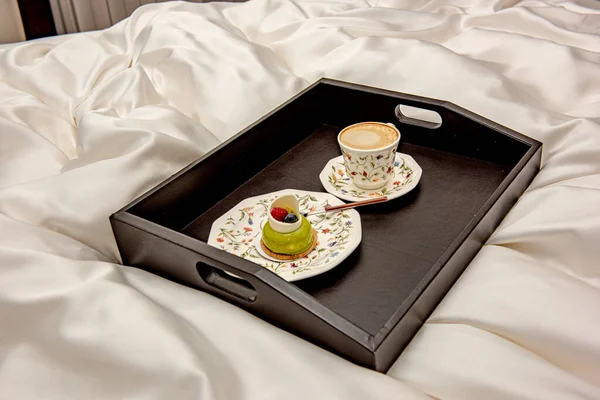 早上在大床上放咖啡在床单上的托盘 — 图库照片