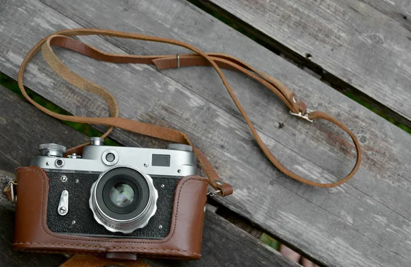 在一个木制蹩脚桌上的皮革盒旧相机 — 图库照片