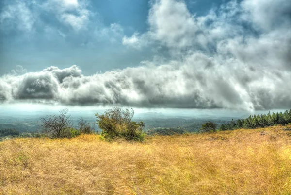 HDR olhar de um céu nublado visto de um topo de montanha gramado — Fotografia de Stock