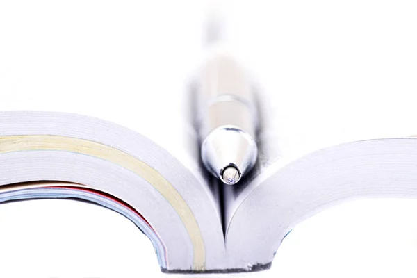 Macro shot of a pen in the middle of a book isolated on white — Stock Photo, Image