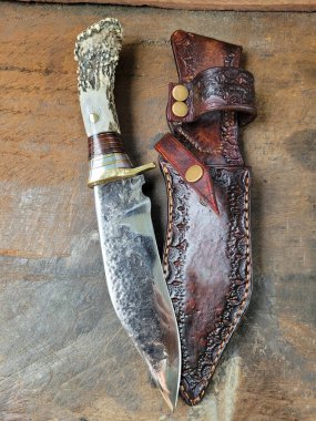 Elle dövülmüş dağ bıçağı ve deri bir kılıf.