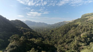 Parlak mavi gökyüzü ve Panama 'nın orta dağlarındaki yemyeşil ormanlı bir dağ koridorunun havadan görünüşü..
