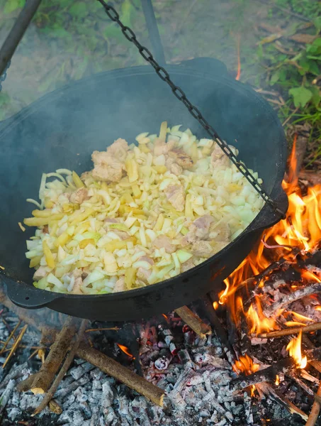 heating kettle with food on fire. beginning cooking