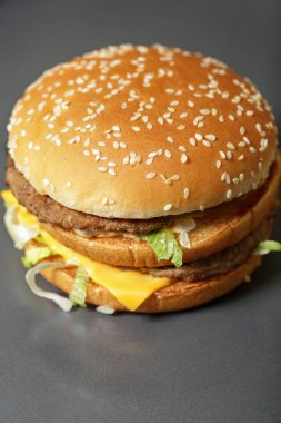 Lezzetli taze burger marul, peynir ve soğan koyu arka plan üzerinde Close-up