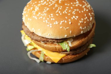 Lezzetli taze burger marul, peynir ve soğan koyu arka plan üzerinde Close-up