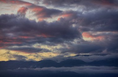 Gün batımında gökyüzünde Dağların üzerinden güzel bulutlar