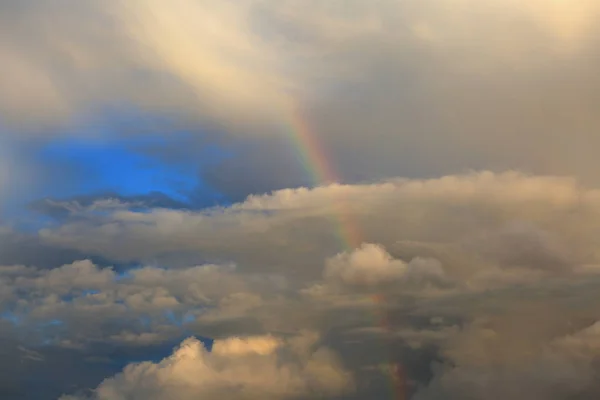 Beautiful heavenly landscape. Rainbow in the sky among the clouds