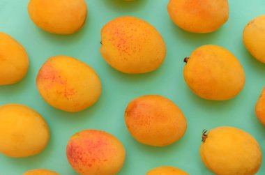 Birçok parlak sarı kayısı yeşil. Bir meyve saklamak için iyi bir arka plan.