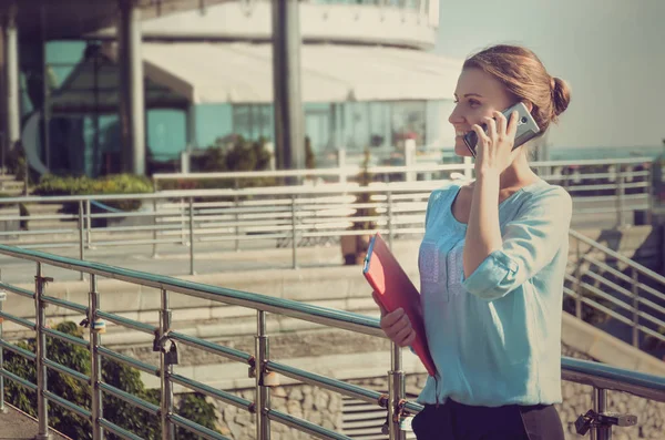 自信冷静的商界女性在电话里聊天 拿着一本红色的笔记本 上面有重要的信息 电话洽谈 — 图库照片