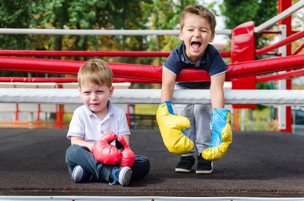 Two boys three years in a boxing ring. Taste of victory. The joyful laughter of the winner and the bitter tears of the loser