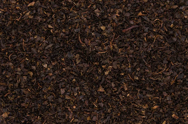 Black leaf tea background. Abstract background from dry tea leaves