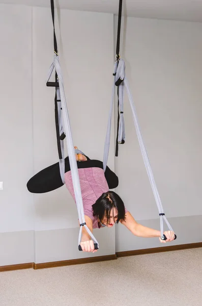 Femme attrayante faisant du yoga de mouche dans un hamac dans le studio — Photo