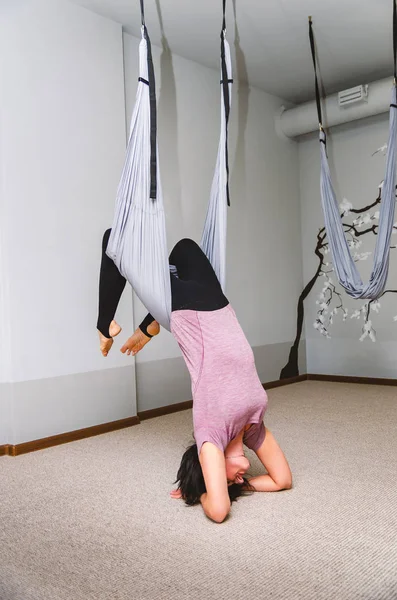 Mulher atraente fazendo ioga mosca em uma rede no estúdio — Fotografia de Stock