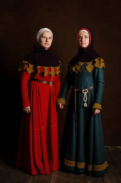 Two sisters (twins) in medieval costumes play the nobility. Port — Stock Photo, Image