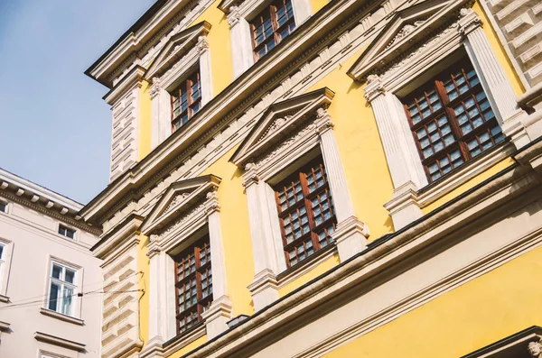 windows of the old European house are yellow with a bas-relief o