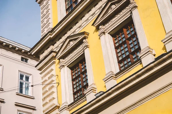 windows of the old European house are yellow with a bas-relief o