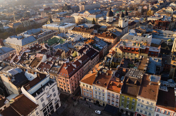 Top view of the roof of an old European city - Lviv. Old architecture, old metal rusted roofs, view of the city from the town hall at sunset