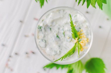 Katmanlar halinde sıralanmış bir bardak ısırgan ve yumurta ile Egzotik salata. 