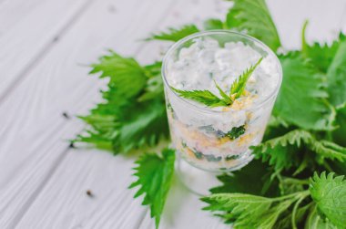 Katmanlar halinde sıralanmış bir bardak ısırgan ve yumurta ile Egzotik salata. 