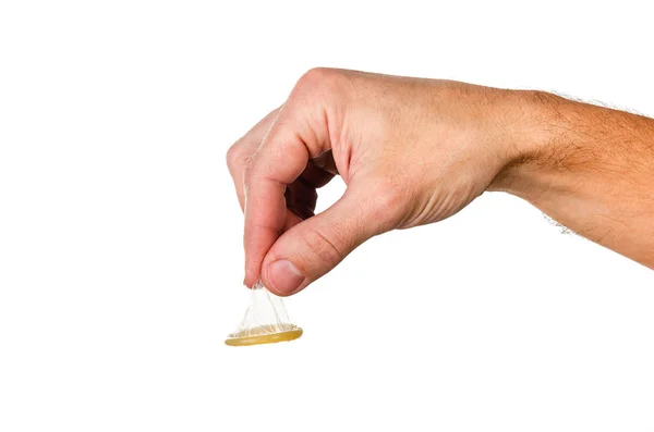 Homem segura um preservativo pela parte superior com dois dedos . — Fotografia de Stock