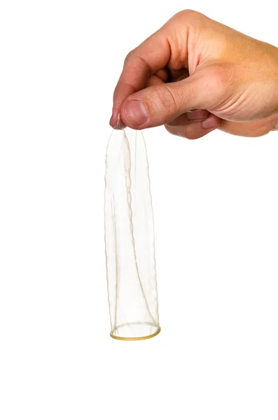 Mano masculina aislada sobre un fondo blanco sosteniendo un condón. Un hombre. — Foto de Stock