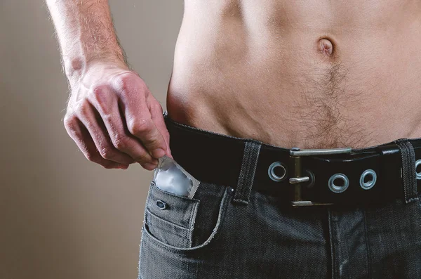 Bis zur Taille zieht ein nackter, attraktiver Mann in schwarzen Jeans einen Cond — Stockfoto