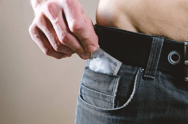 Naar de taille een naakte, aantrekkelijke man in zwarte jeans trekt een cond — Stockfoto