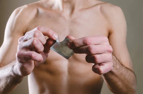 In de taille een naakte, aantrekkelijke man in zwarte jeans breekt (open — Stockfoto