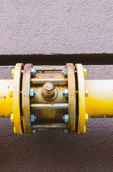 yellow gas pipe with a crane goes along the facade of a new mult