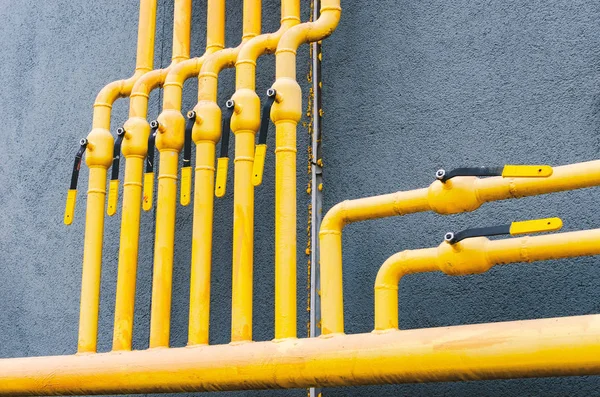 Tubo de gas amarillo con una grúa va a lo largo de la fachada de una nueva multa — Foto de Stock