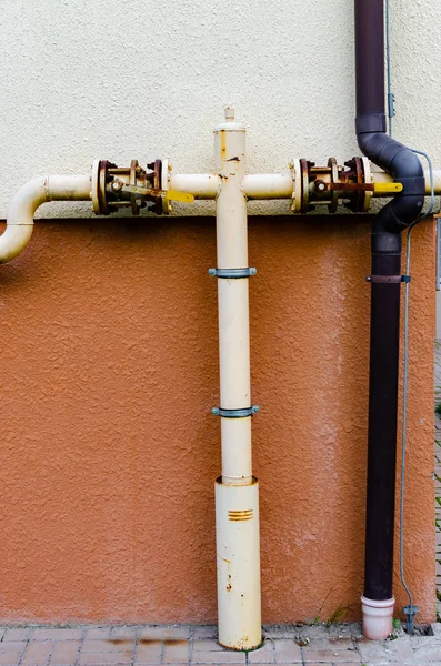 yellow gas pipe with a crane goes along the facade of a new mult