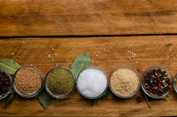 Variety of spices in round glass bowls - ground ginger, hops-sun — Stock Photo, Image