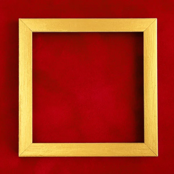 Square golden wooden frame on red velvet background. — Stock Photo, Image