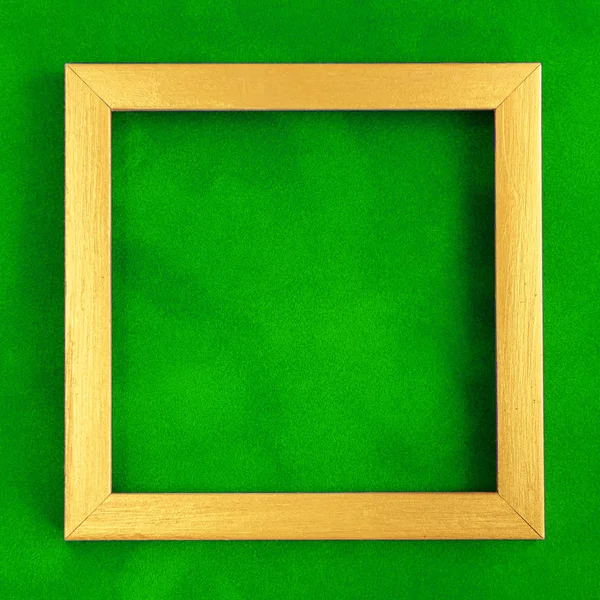 Τετράγωνη χρυσή ξύλινη κορνίζα σε πράσινο βελούδινο φόντο. — Φωτογραφία Αρχείου