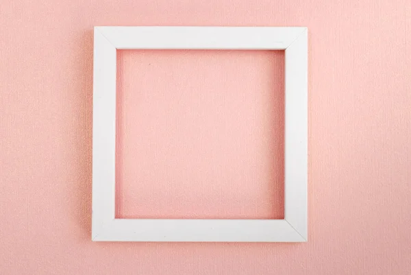 Biała kwadratowa ramka na różowej perłowej desce. — Zdjęcie stockowe