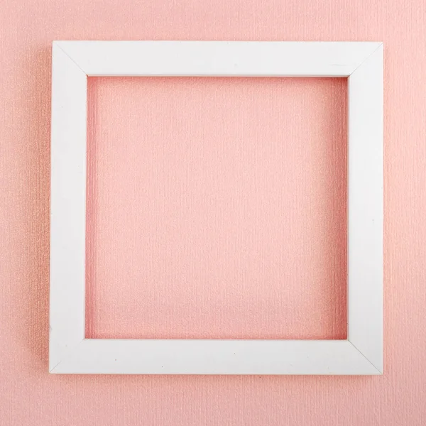 Bílý čtvercový rám na růžové perleťové desce. — Stock fotografie