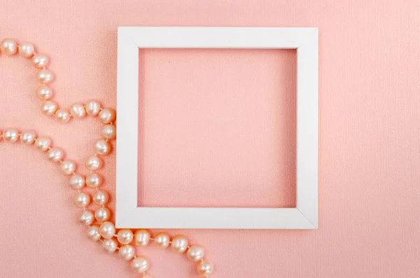 Quadro quadrado branco com pérolas em uma placa de design de pérola rosa — Fotografia de Stock