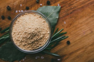 Ahşap bir masa üzerinde baharat ile Yuvarlak cam kase - zemin zencefil. 