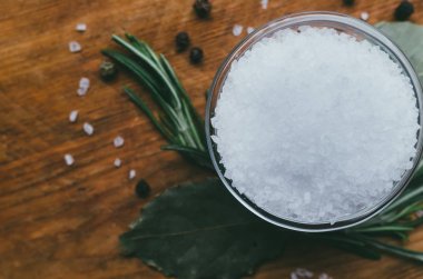 Ahşap bir masada yuvarlak cam baharat kase - deniz tuzu. 