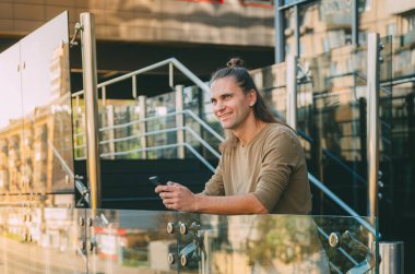 Çekici genç adam (hipster) bir akıllı telefon bir mesaj yazıyor 