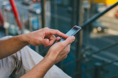 Genç adam (hipster) bir akıllı telefon tutuyor. Bir adam karmaşa yazar.