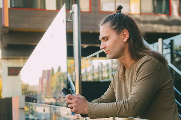 Atrakcyjny młody człowiek (Hipster) pisze wiadomość na smartfonie — Zdjęcie stockowe