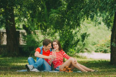 Aşık mutlu çift çayırdaki parkta dinleniyor. Bir çift