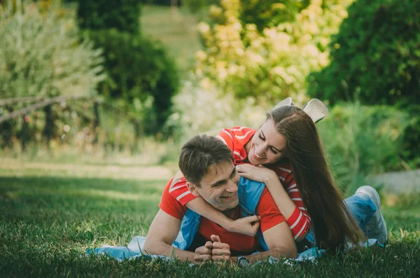 Lyckligt par i kärlek vilar i parken på ängen. Ett par o — Stockfoto