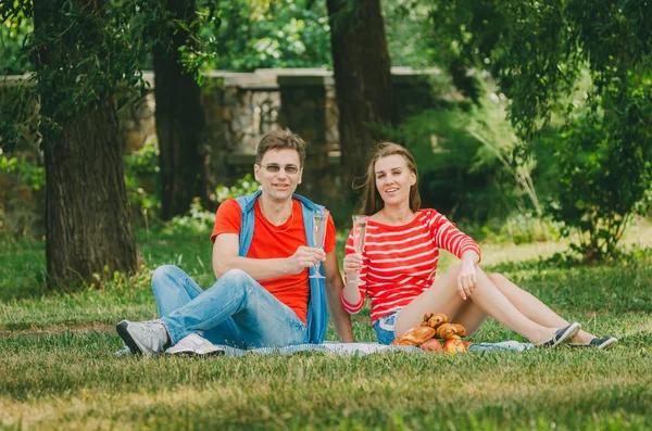 Casal feliz apaixonado descansando no parque no prado. Um casal. — Fotografia de Stock