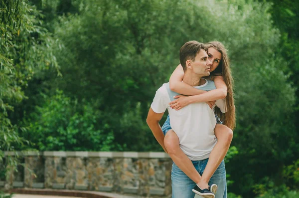 Bella coppia in abiti luminosi passeggiate in un parco estivo nel — Foto Stock