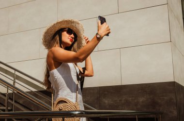 Beyaz bir elbise ve hasır şapka güzel ince kız bir sel alır