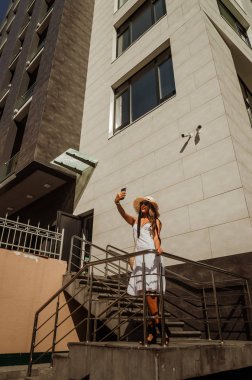 Beyaz bir elbise ve hasır şapka güzel ince kız bir sel alır